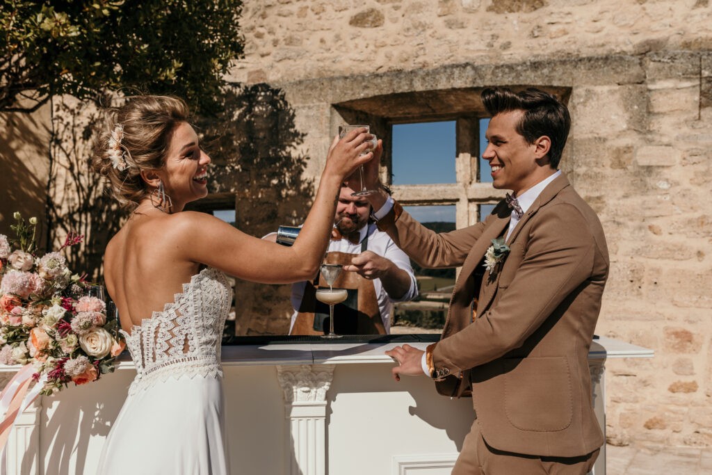Christy Lacour Gianini, robe de mariée bustier dentelle, bar à cockail mariage, barman mariage, inspiration mariage Gard, bar mariage Douce Ivresse, costume de mariage marron, trinquer, Hôtel Vieux Castillon du Gard
