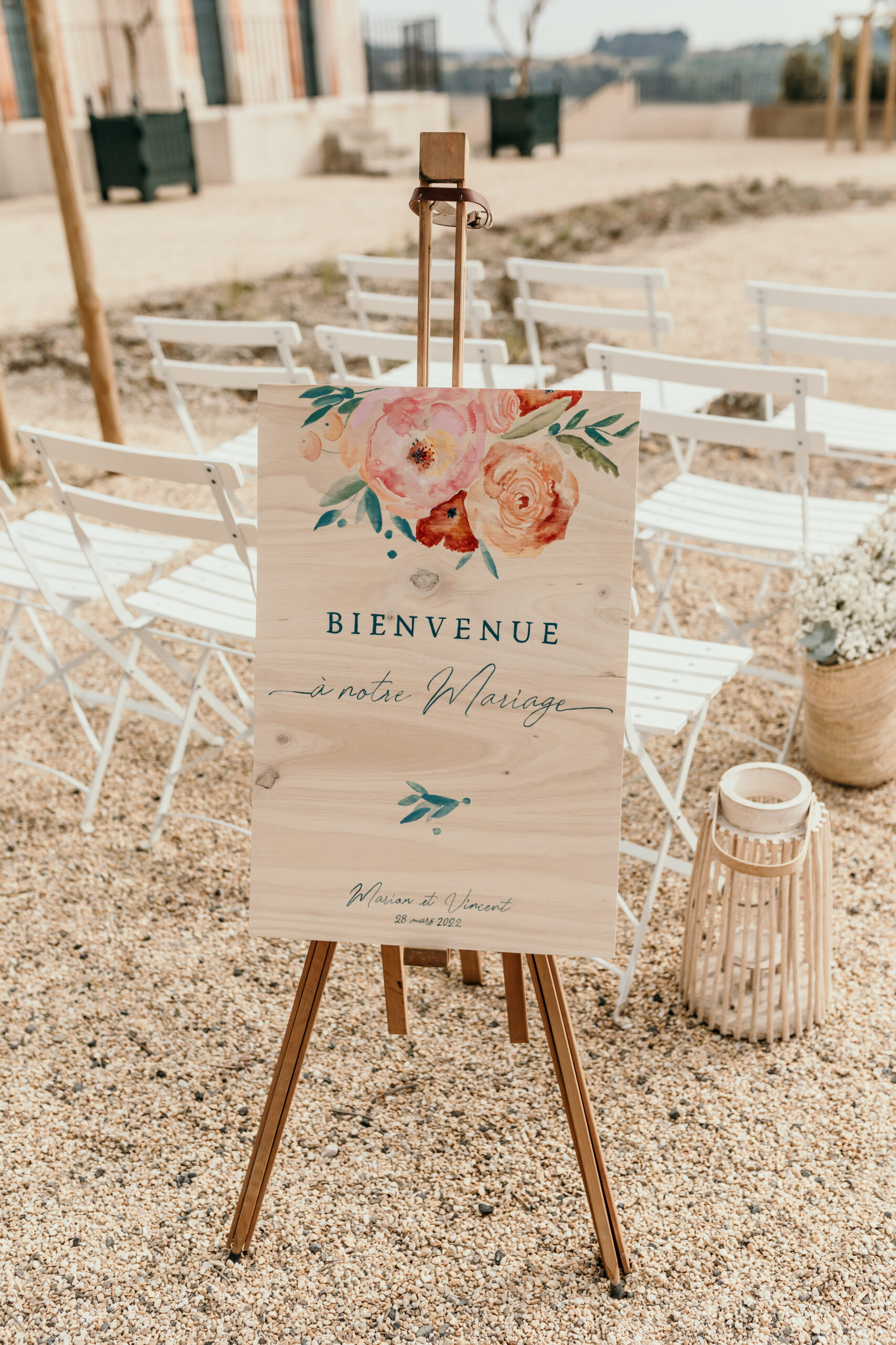 panneau de bienvenue mariage, illustrations aquarelle, fleurs en aquarelle, chevalet en bois, chaises square blanches, cérémonie laïque mariage, Château Capitoul Narbonne