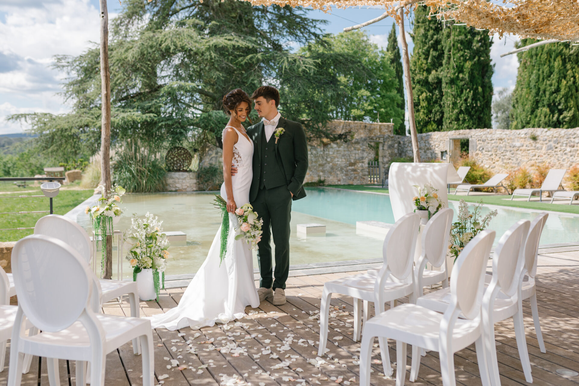 cérémonie laïque mariage, chaise Napoléon blanche, pupitre blanc lumineux, chaises transparentes, piscine, couple de mariés, inspiration mariage Gard